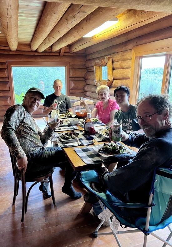 tal-adventures alaskan fishing lodge on the talachulitna river insde photo of guests at a communnity table