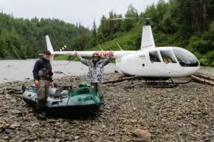 man and raft beside a helicopter on the talachuliltna for a DIY float fishing trip | affordable fishing trips with tal-adventures lodge